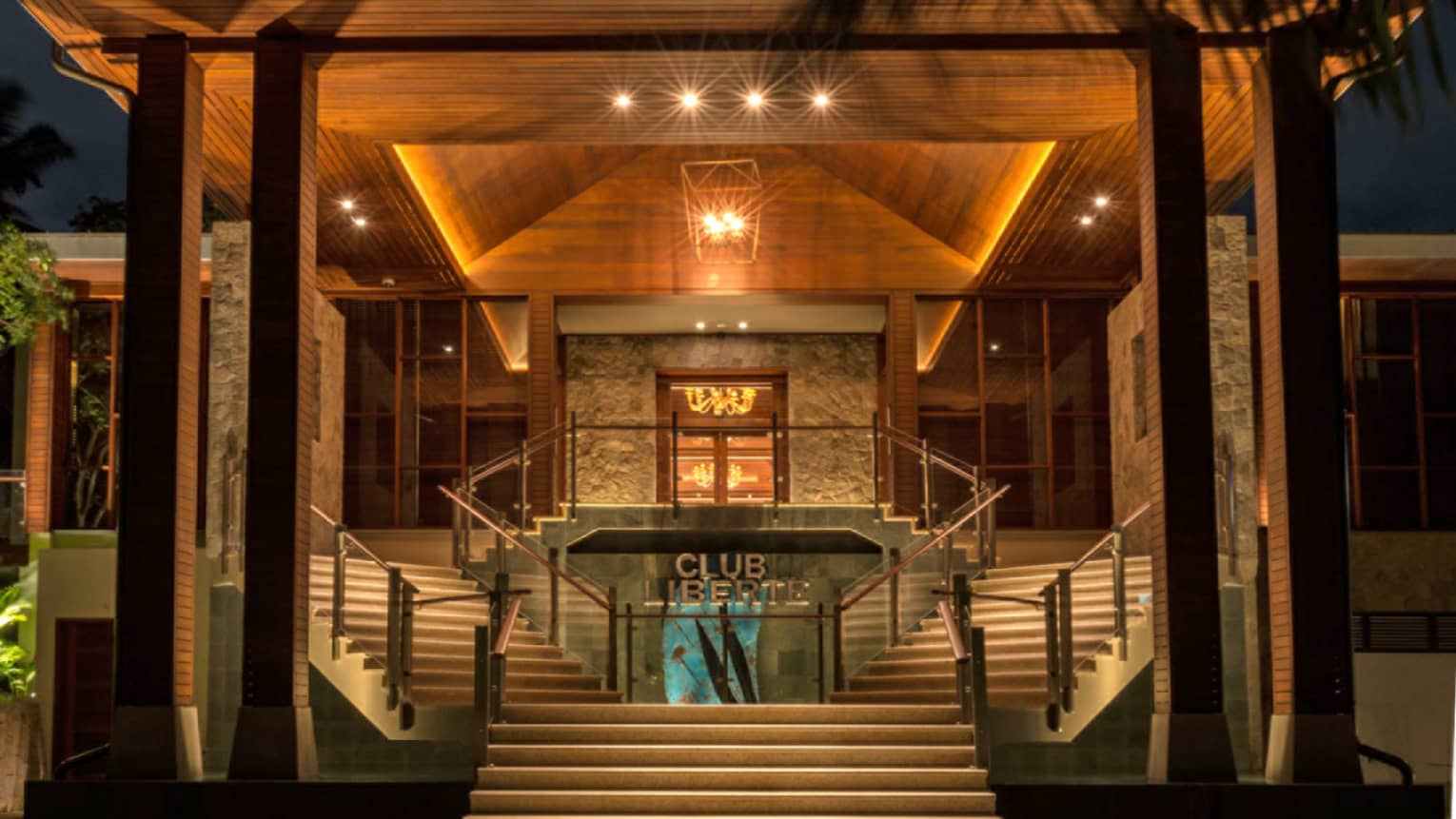 Entrance to Club Liberte, illuminated at night, two stair cases on each side of entry way