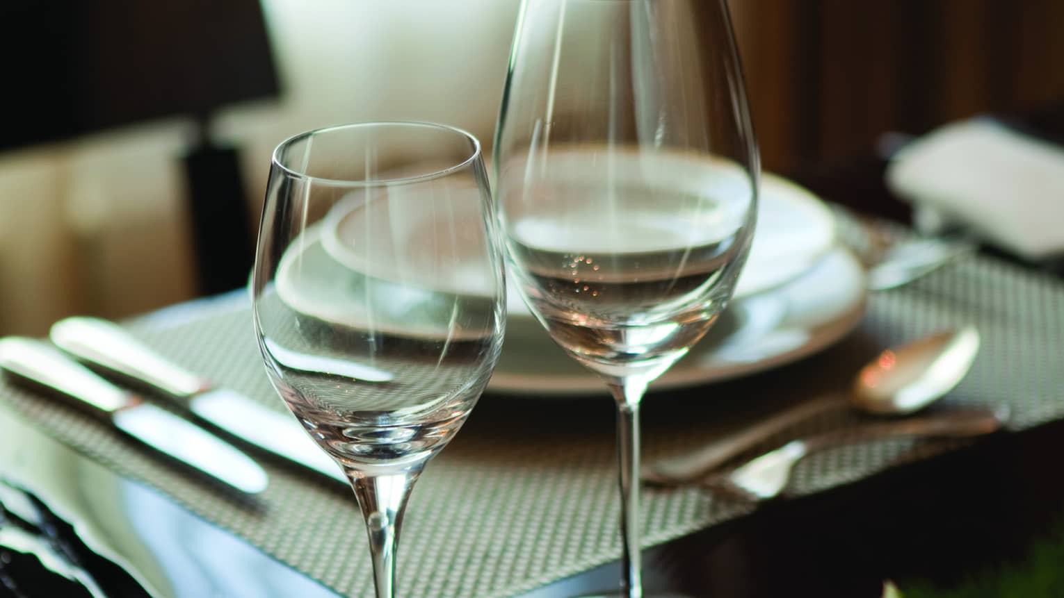 Two wine glasses on hotel room dining table