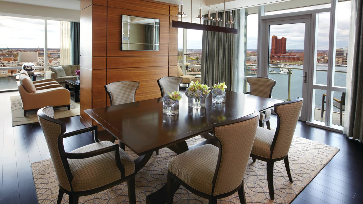 Serene Suite dining table for six, adjoining living room, glass walls with harbour view