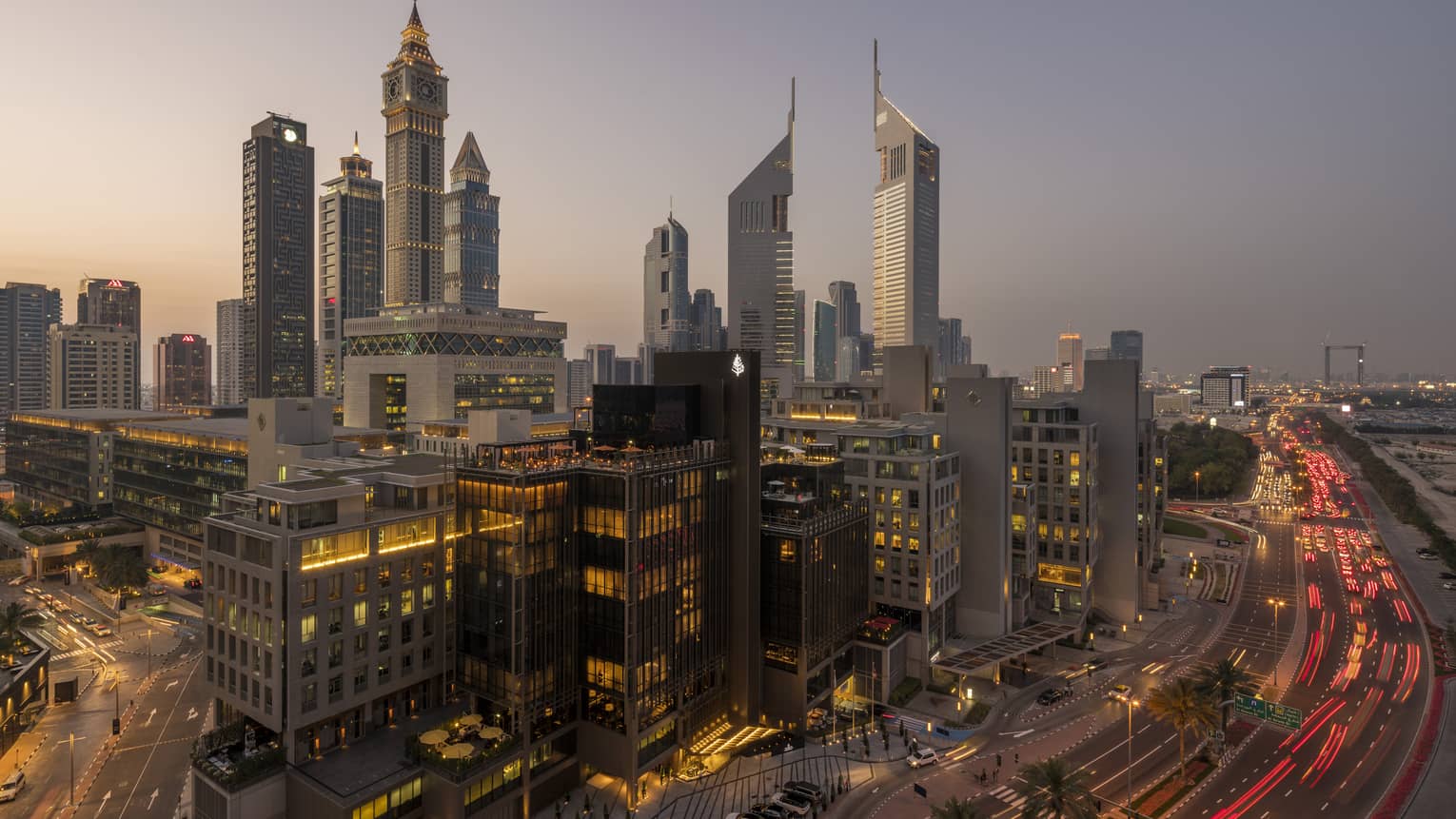 Aerial view of Dubai city skyline, road, lights around Four Seasons International Financial Centre hotel at sunset