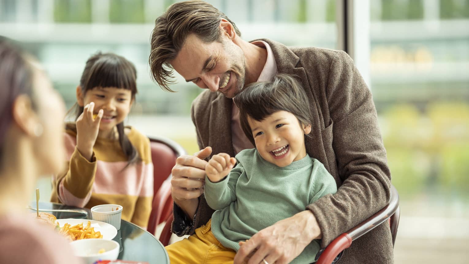 Laughing couple and kids enjoy a meal together
