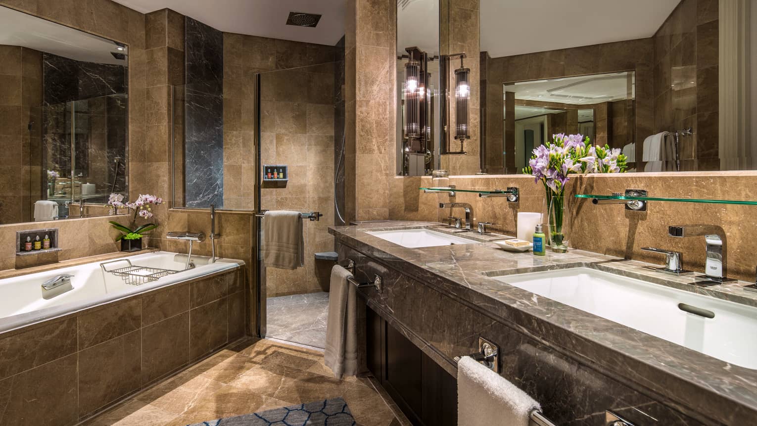 Brown marble bathroom with double vanity, large walk-in shower and soaker tub