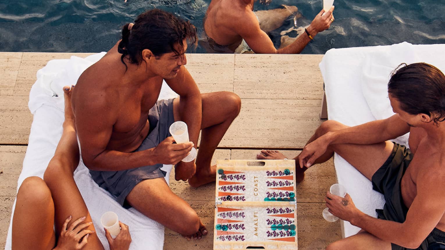  A group of people plying games and swimming.