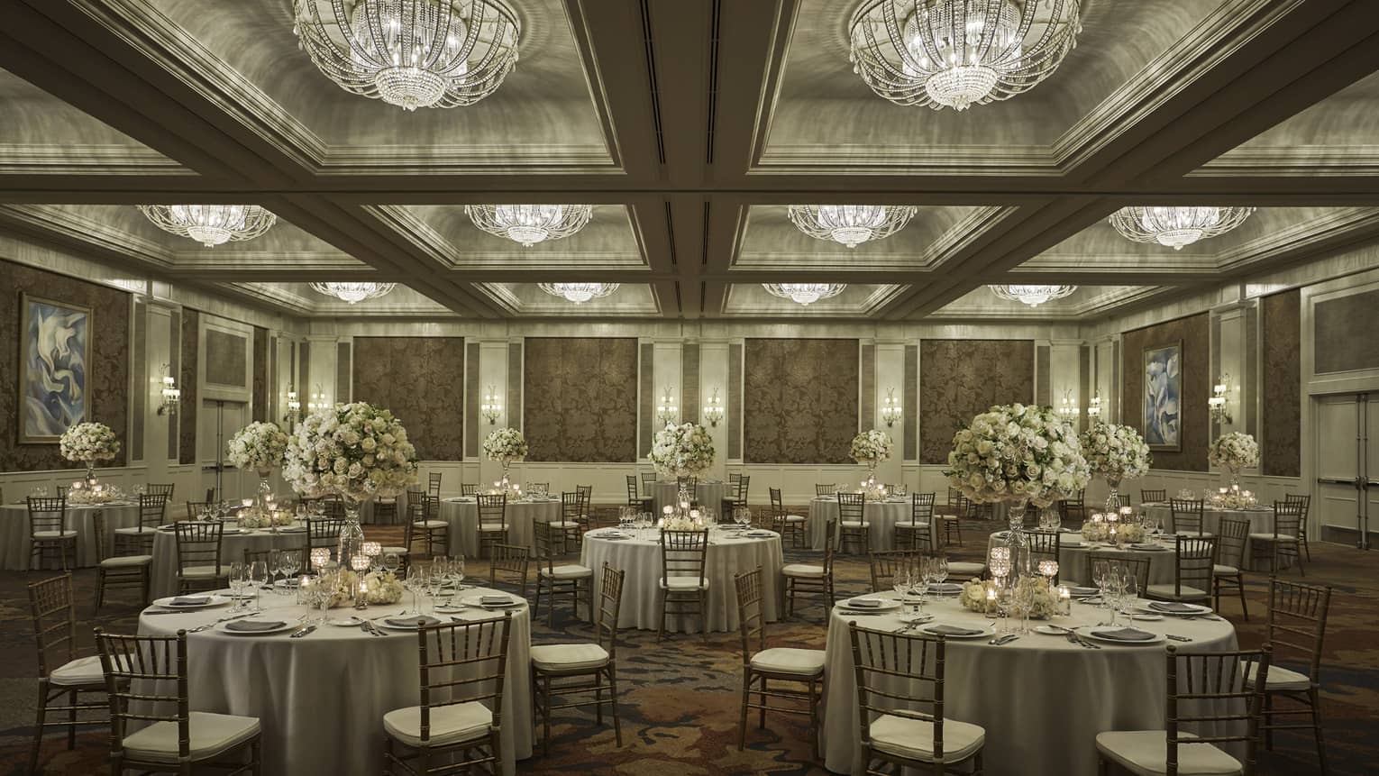 Round tables under crystal chandeliers in elegant Ocean Ballroom event space 