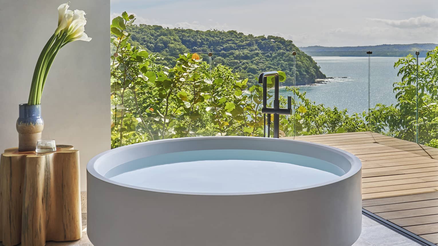 A stand-alone, circular tub on a private terrace overlooking the sea