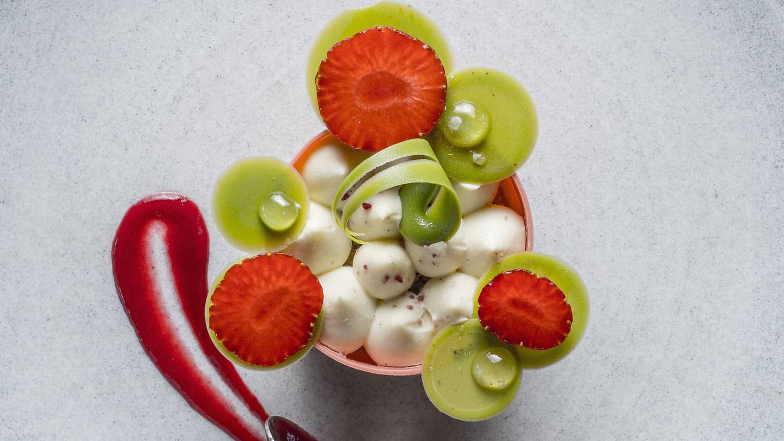 Artisanal dessert, small ice cream scoops garnished with artistic fruit slices, sauce