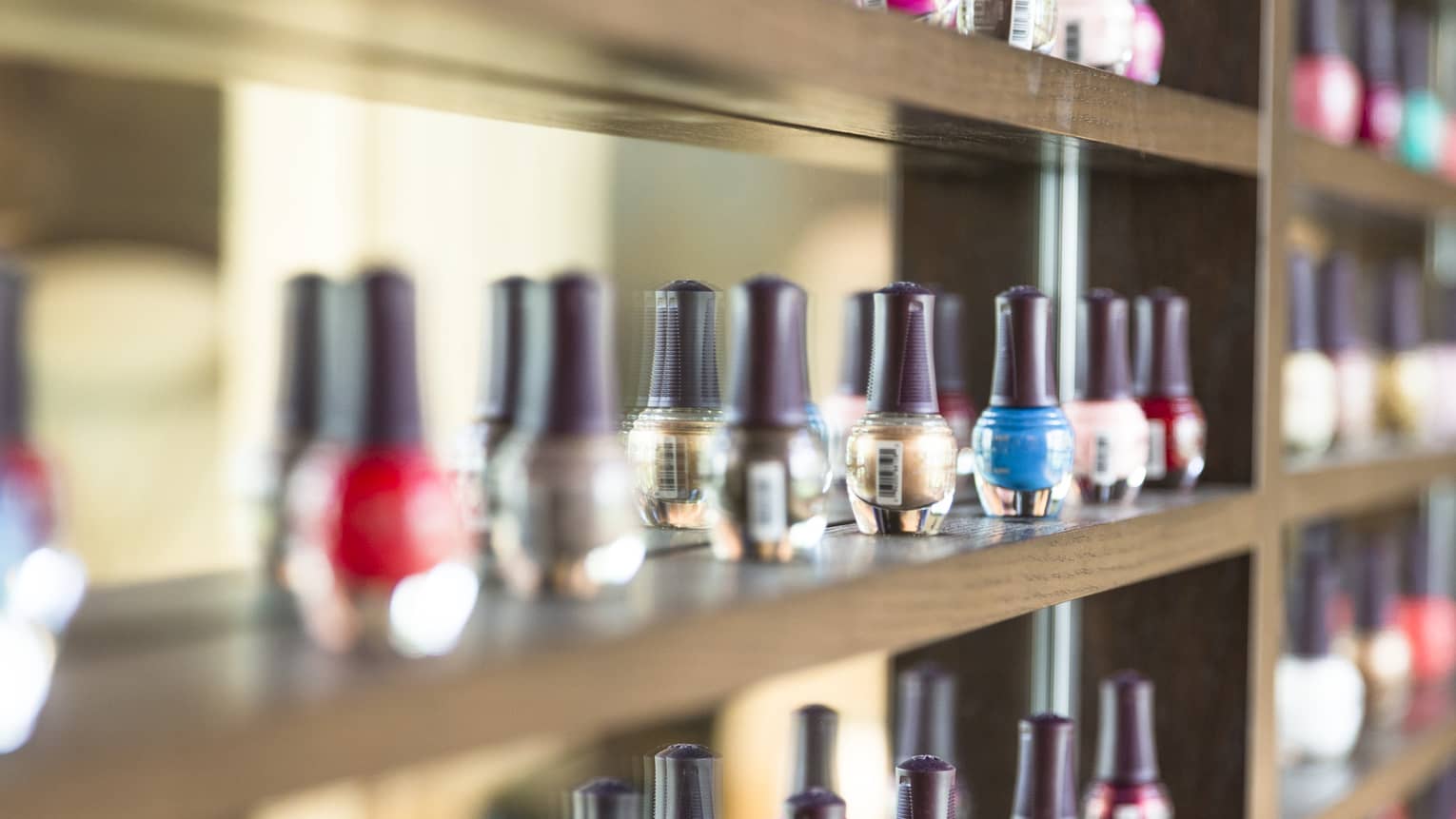 Nail polish bottles on a salon display shelf