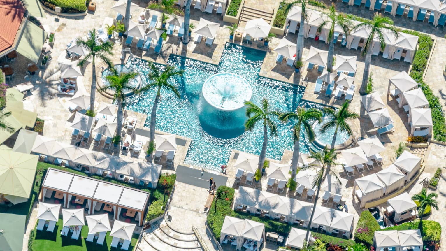 Aerial view of resort pool with fountain, umbrellas and cabanas