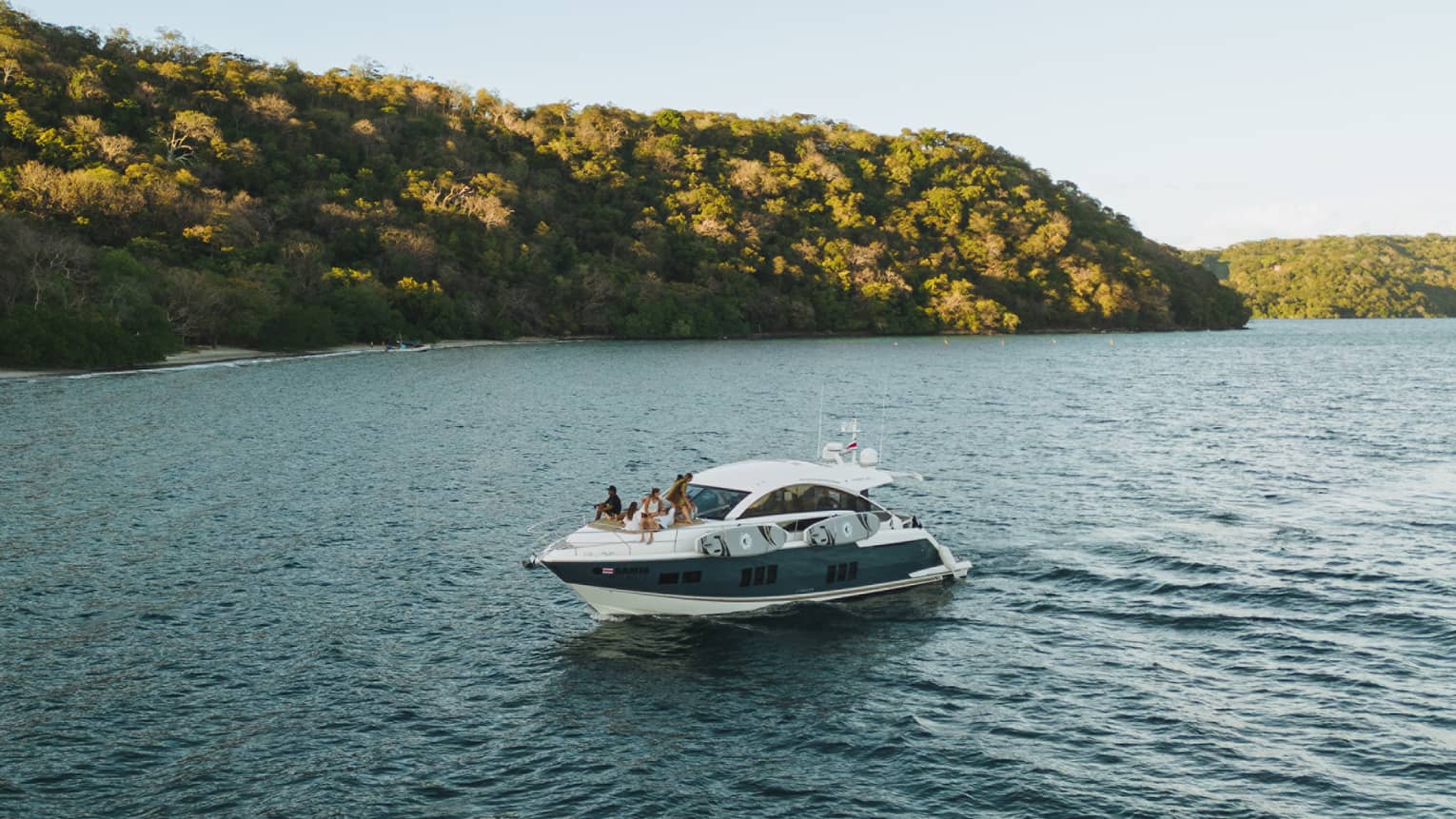 Power boat on water near green hills