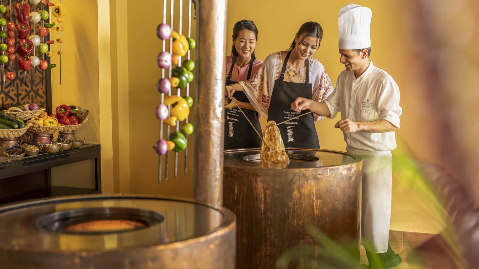 Chef teaches two female guests during Indian cooking class at Baraabaru