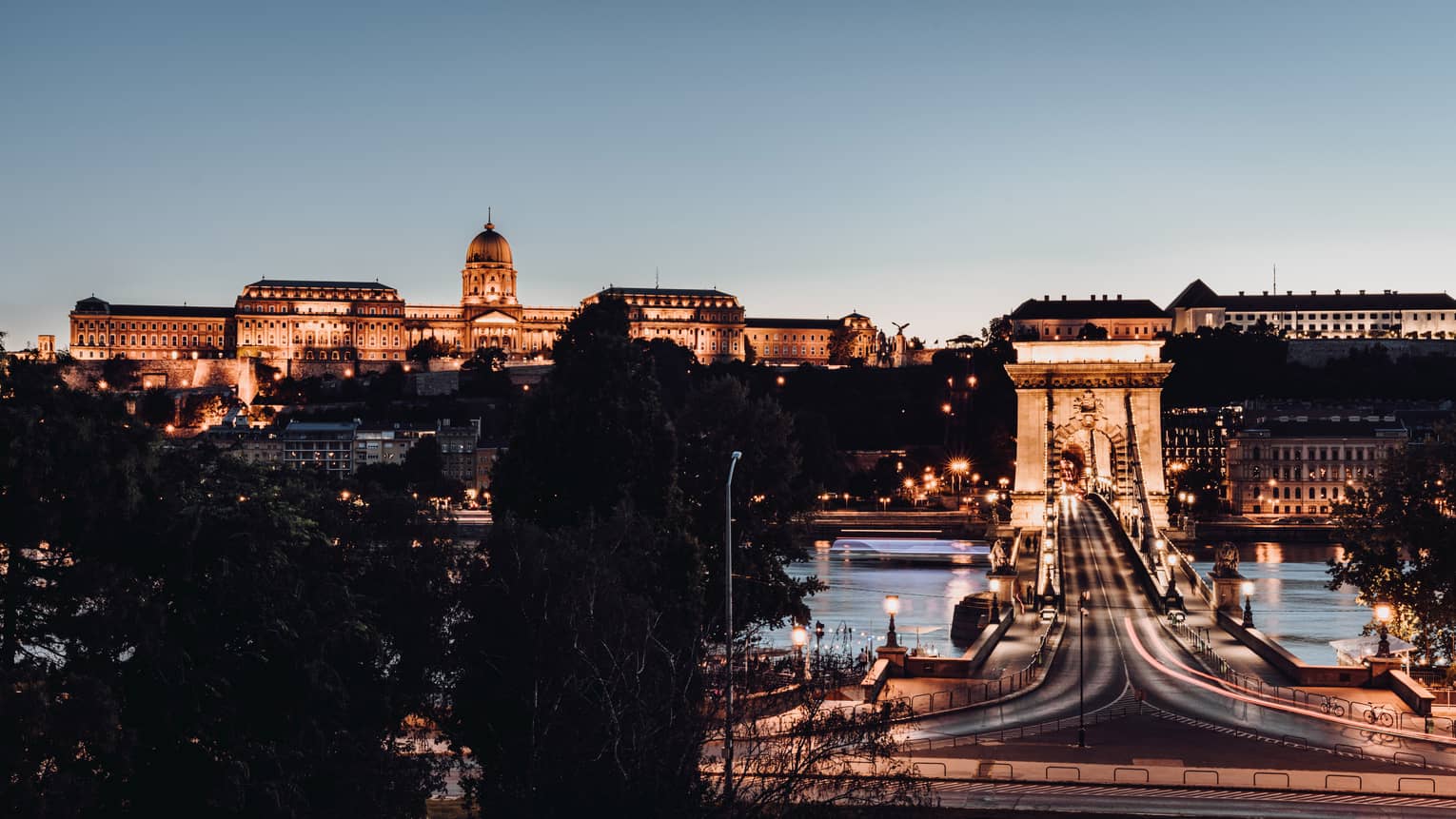 Széchenyi Chain Bridge over the Danube River, uplit Buda Castle at night