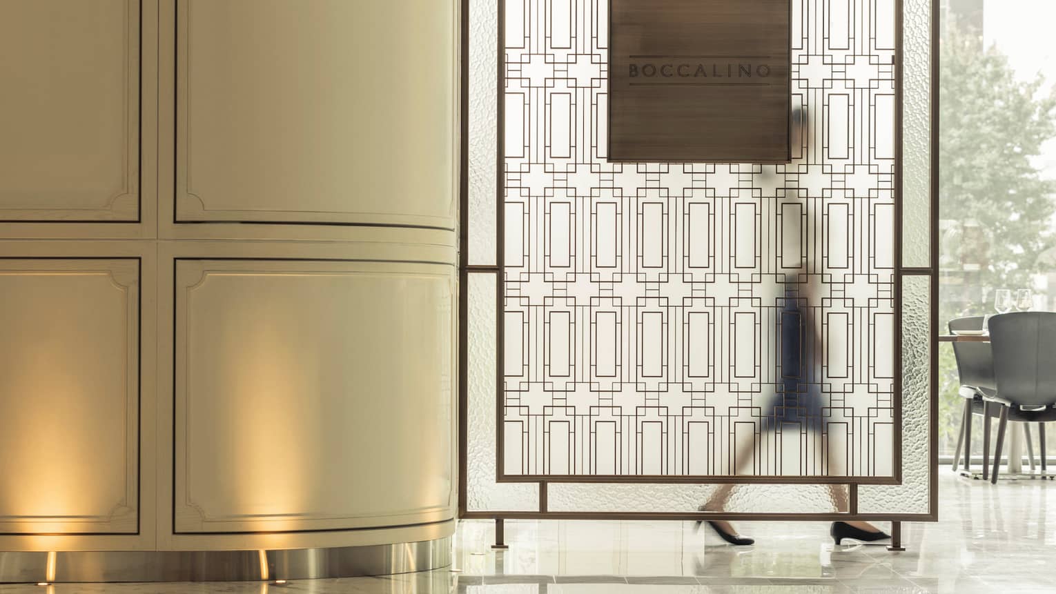 Silhouette of woman walking behind decorative frosted screen in Boccalino dining room