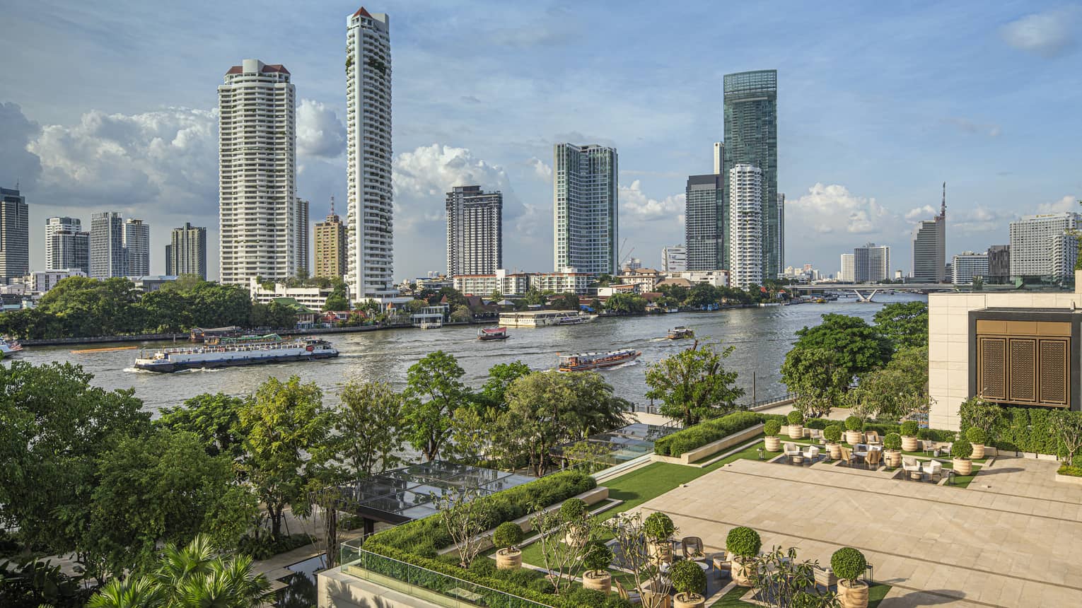 Outdoor terrace with landscaping around edge, view of Chao Phraya River in Bangkok