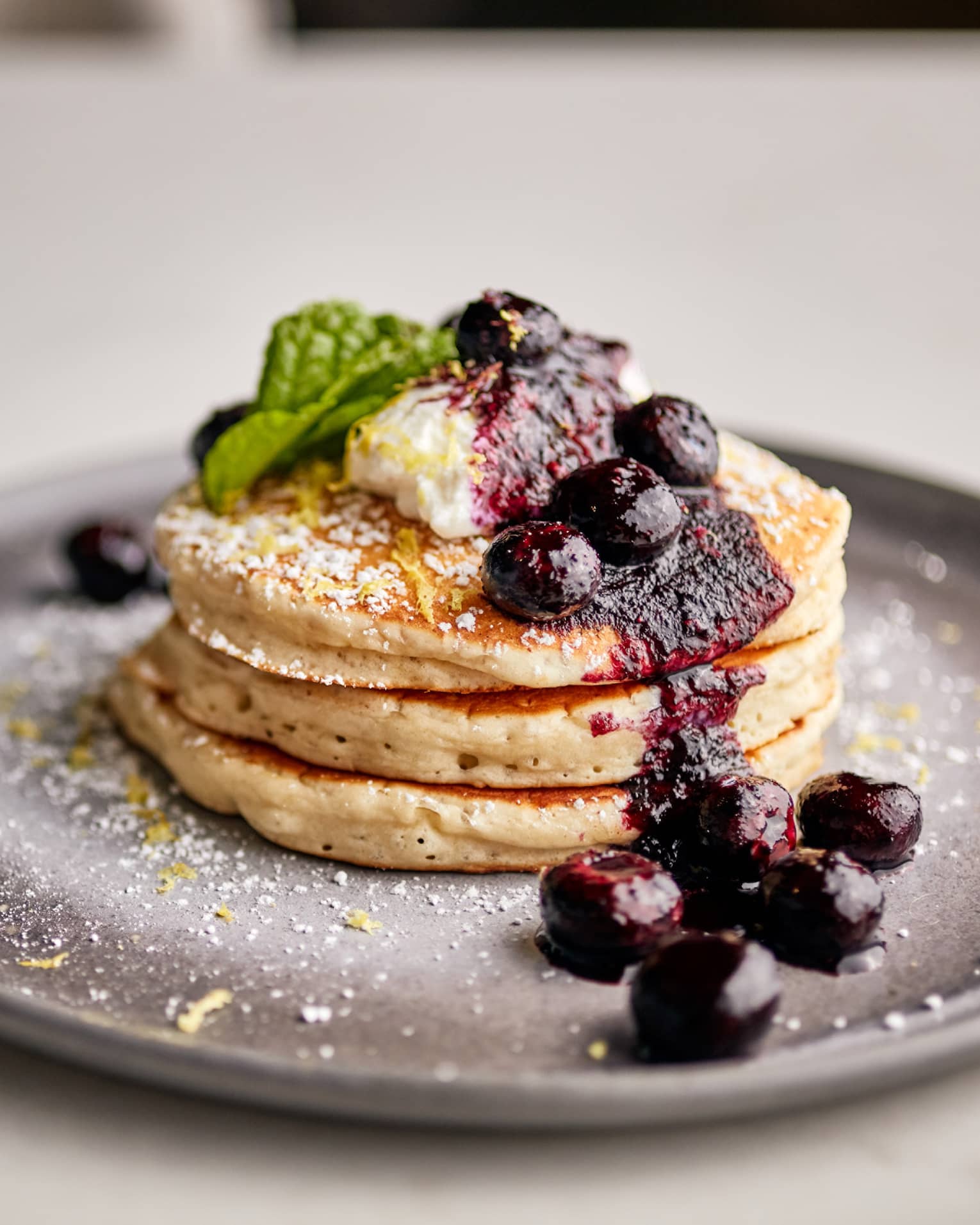 Three pancakes with blueberries on top.