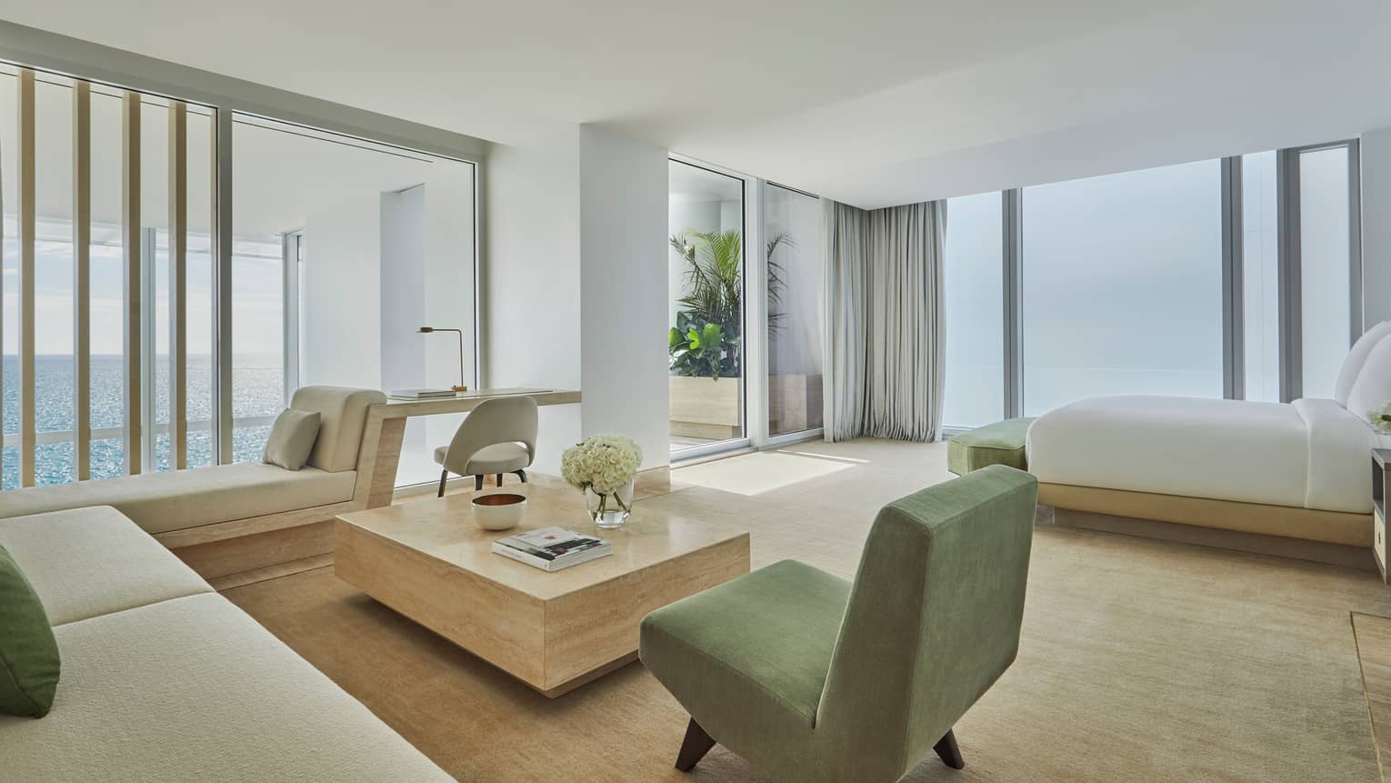 Petnhouse bedroom, floor-to-ceiling corner windows, beige and green sofa, armchair
