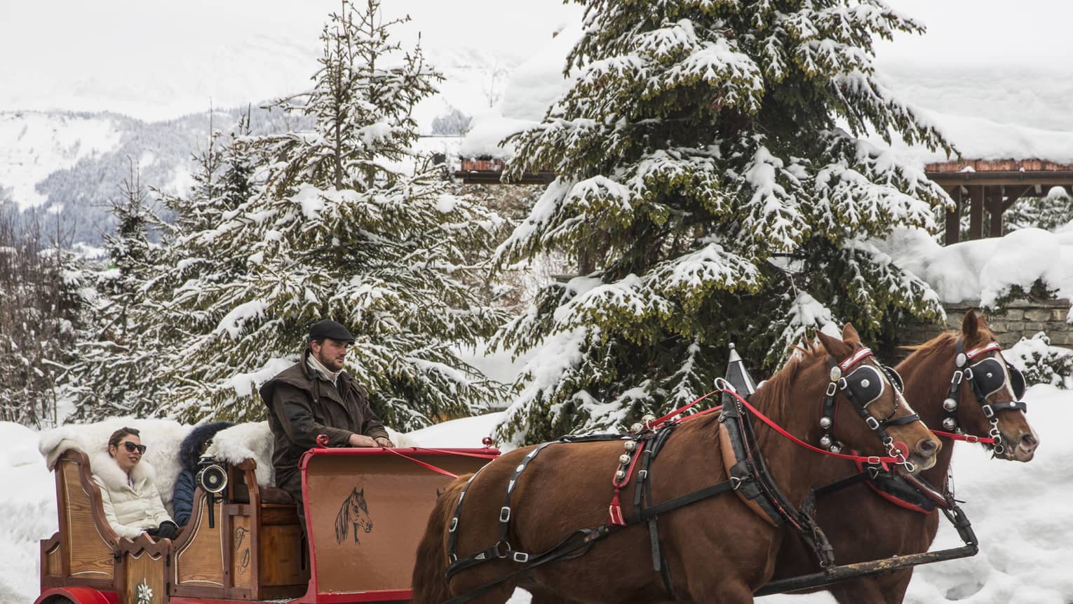 Guests explore a snow covered Megeve in a horse drawn carriage