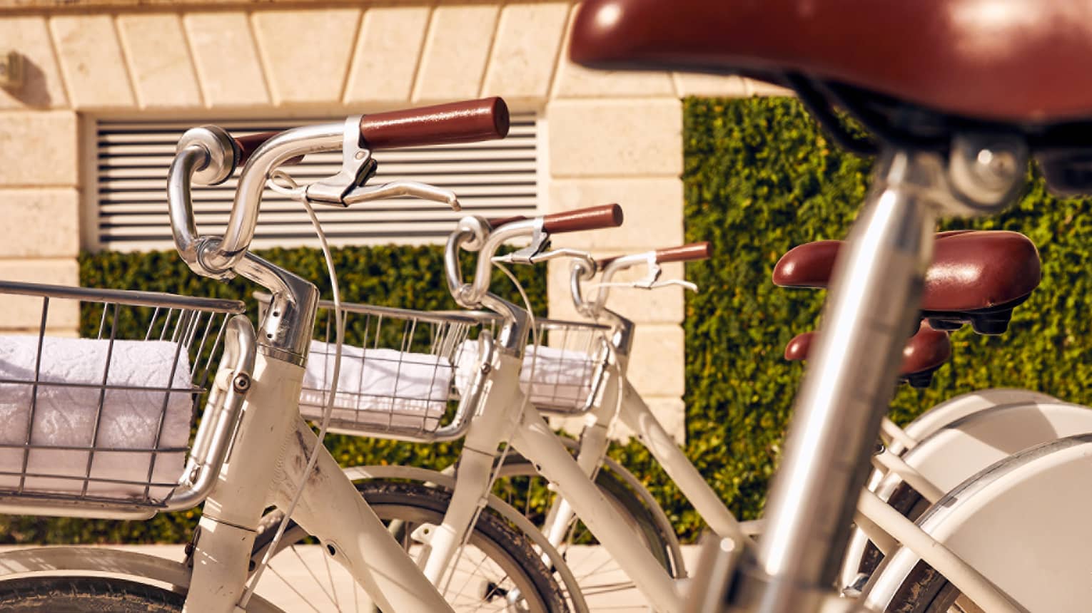 A close up image of white bikes with baskets.