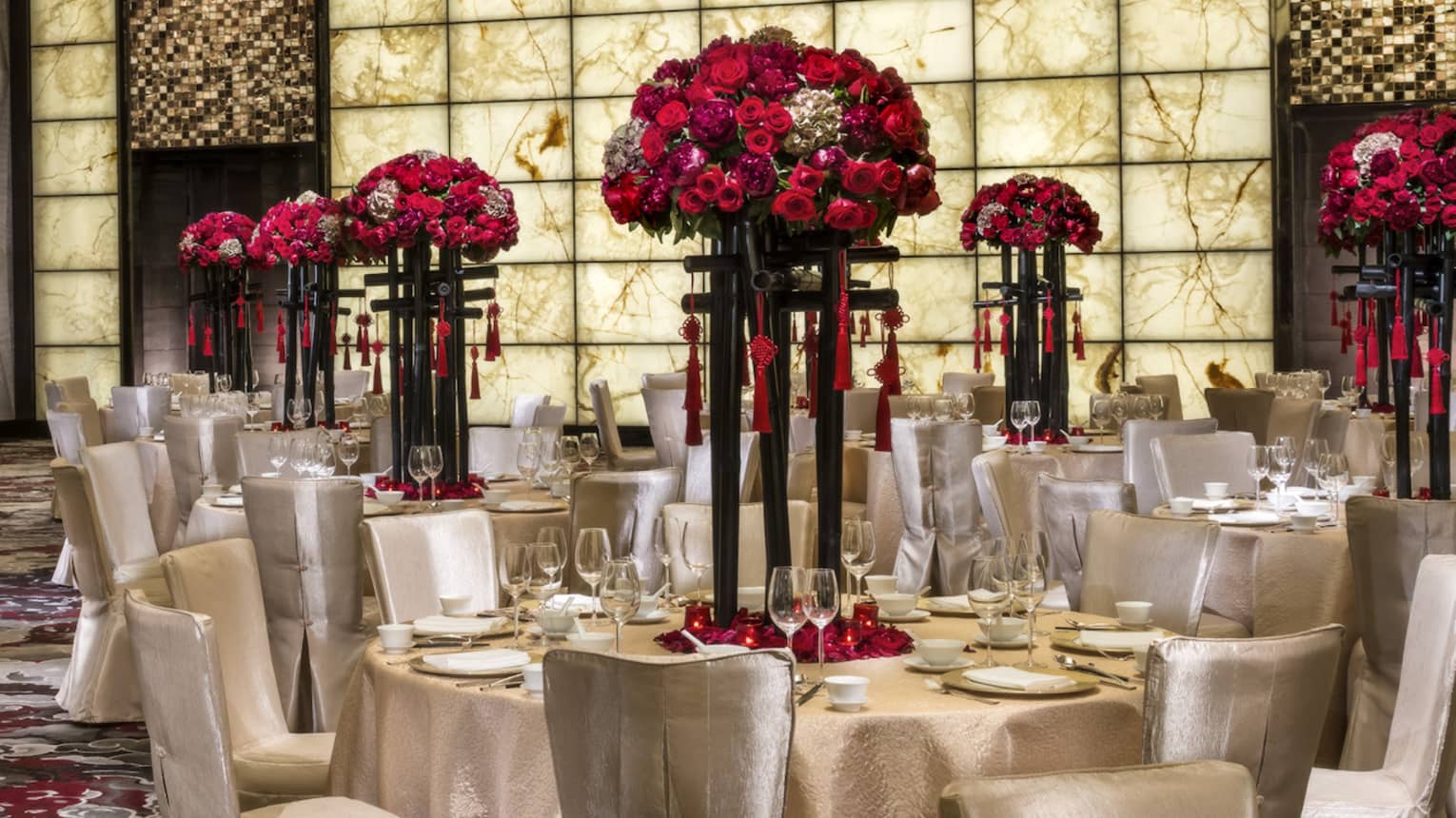 Grand Ballroom banquet tables and chairs with silk linens, red flowers in tall vases 