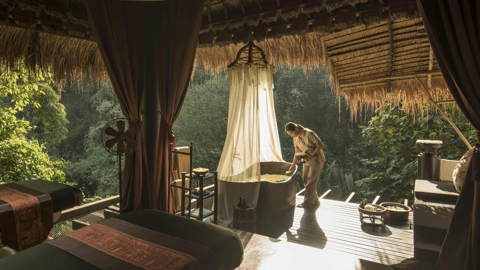 Woman prepares a bath on the jungle terrace