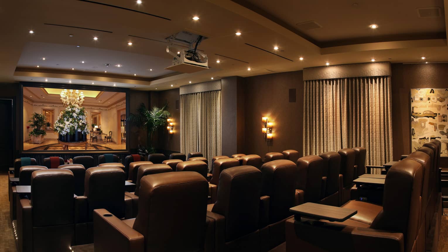 Rows of leather theatre chairs facing screen in movie screening room