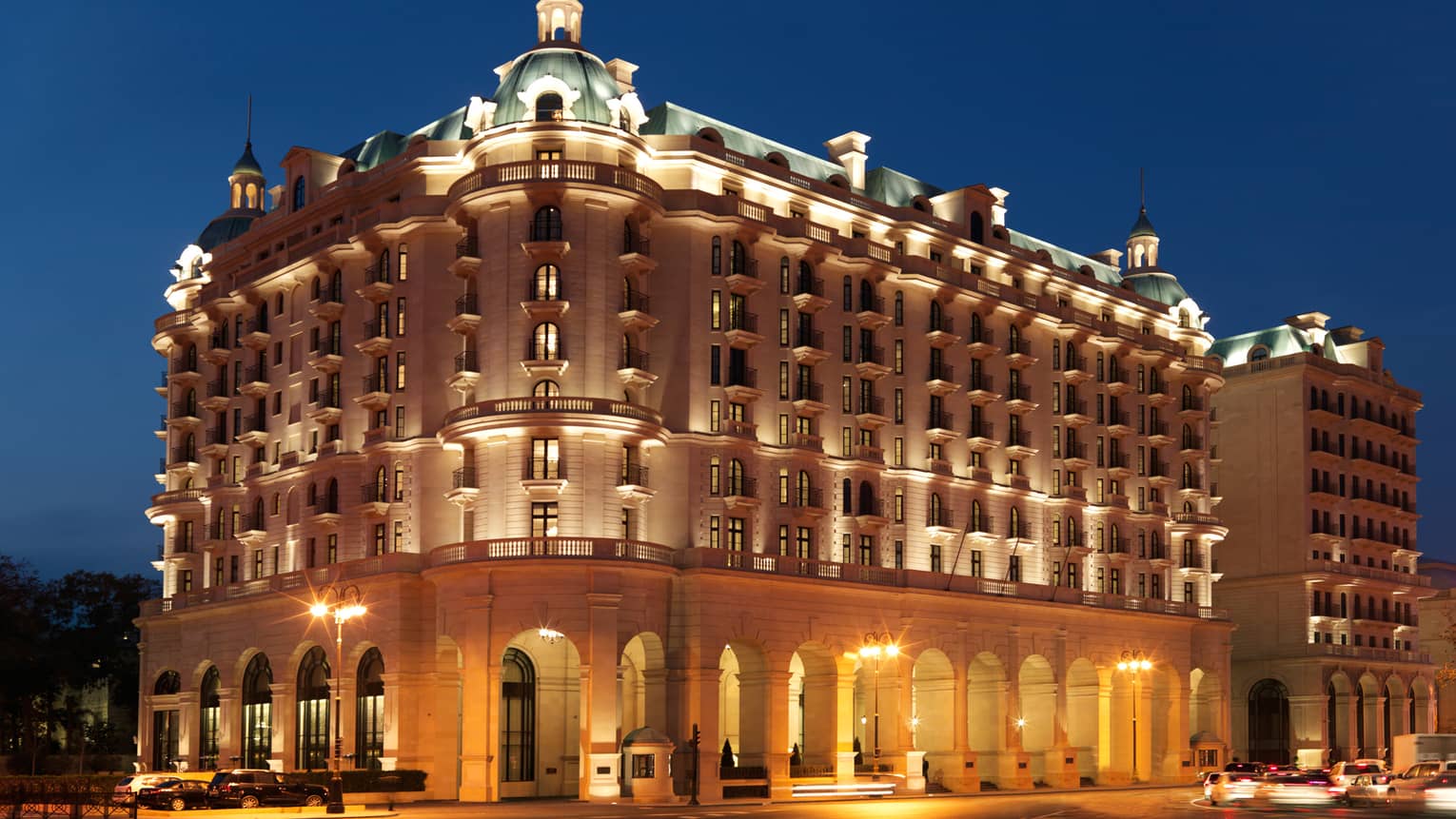 Night view of Baku Four Seasons Hotel Beaux-Arts-style building exterior with lights, illuminated roof