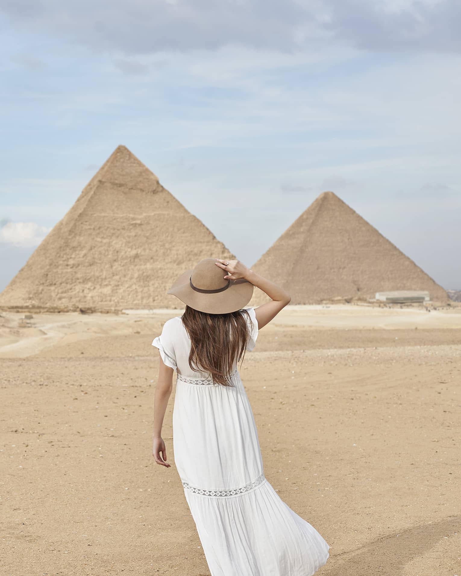 A guest wearing a linen dress observing the Great Pyramids