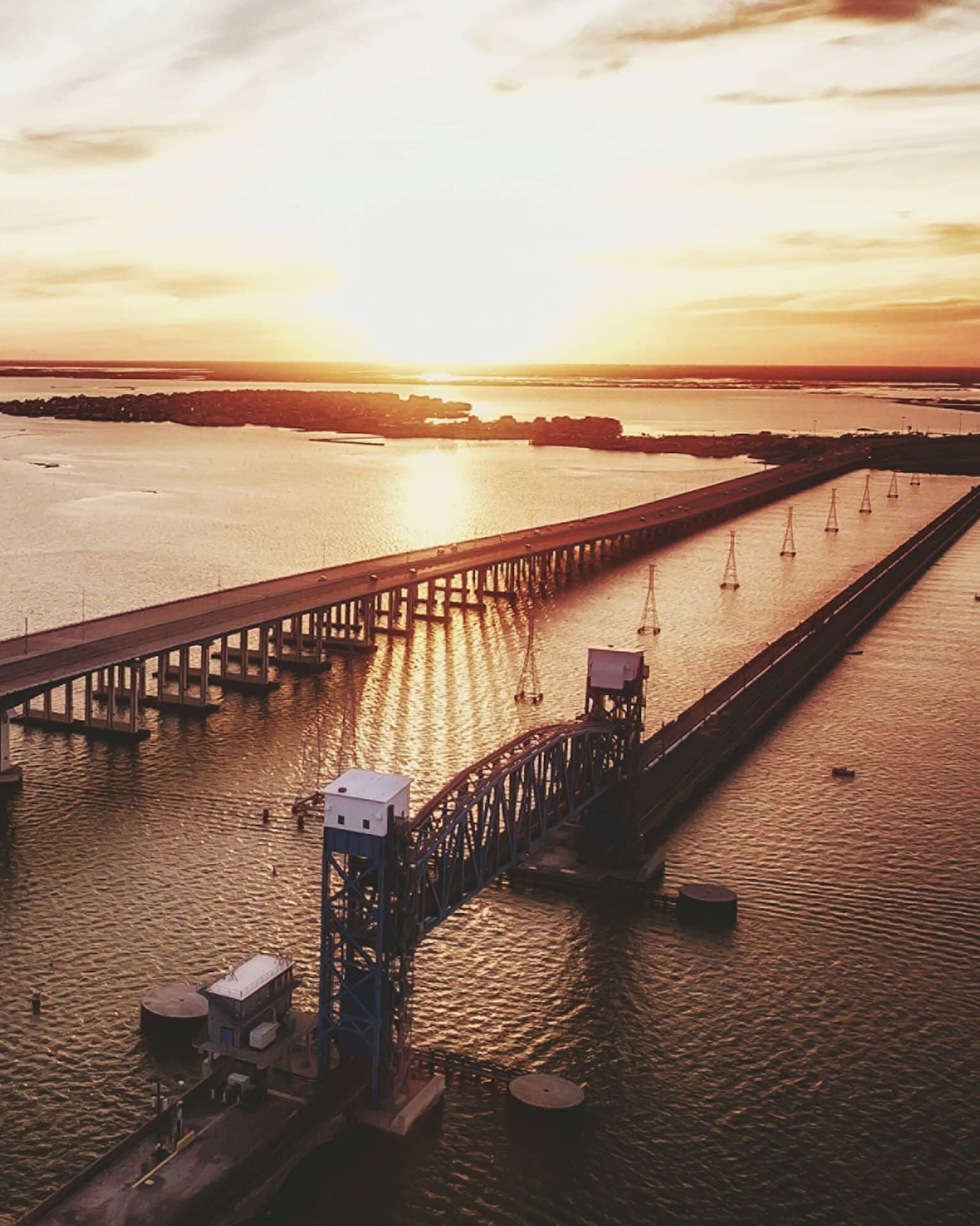 The sun sets over a long bridge in Houston