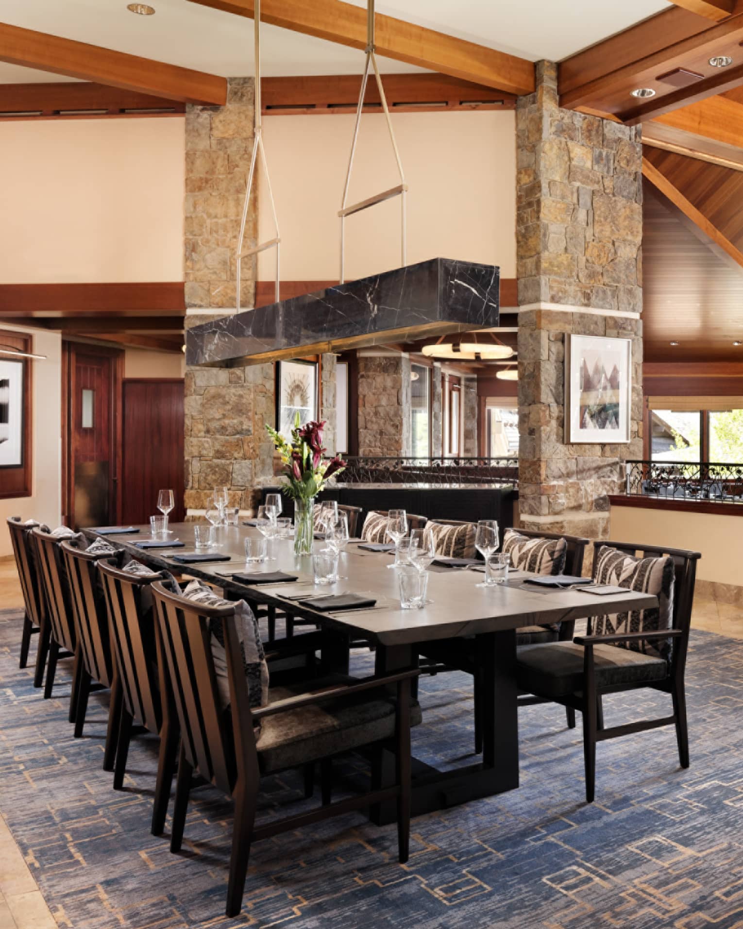 Elegant restaurant dining table with fresh-cut flowers and ten seats on the upper level of Westbank Grill