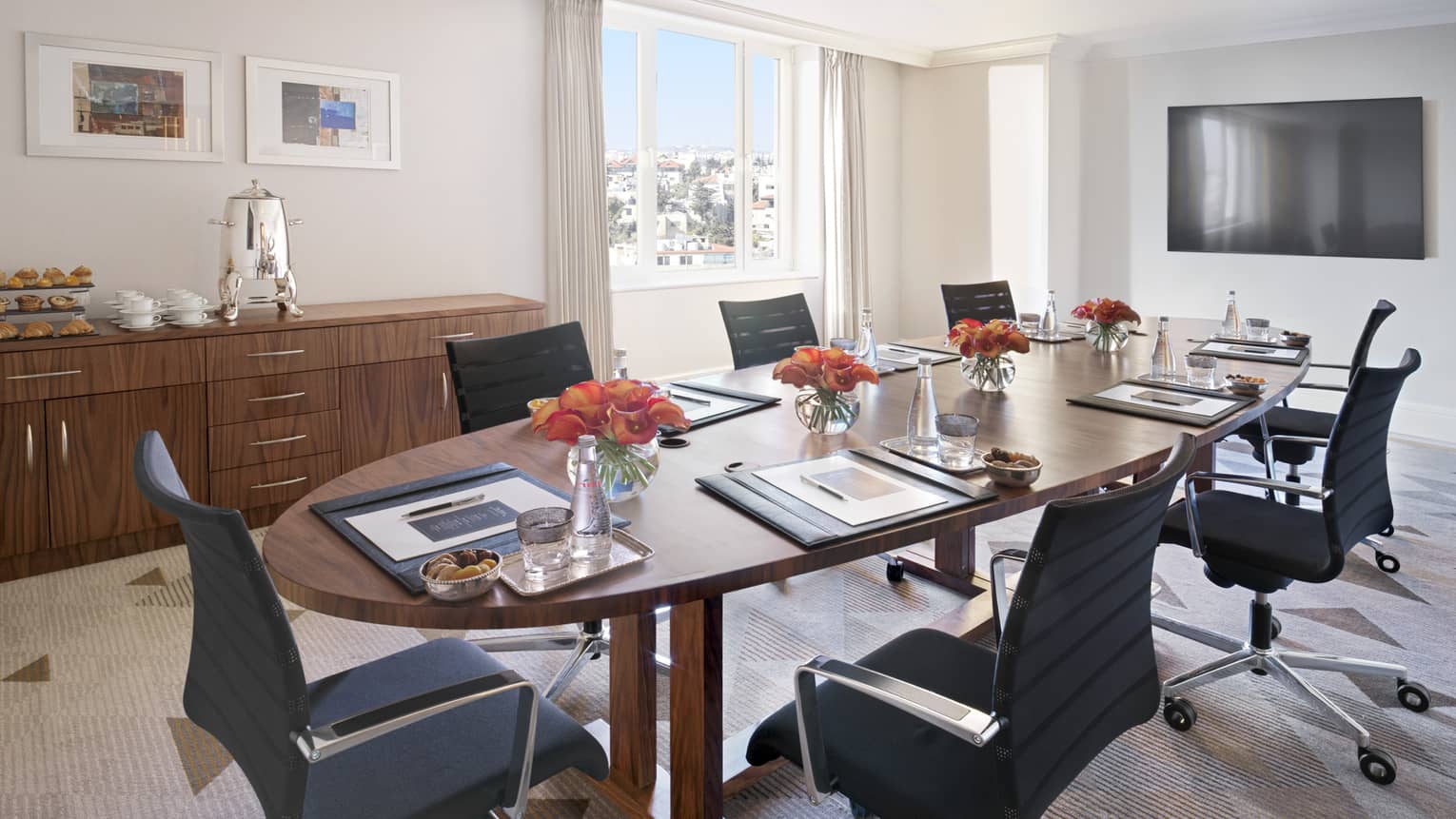 A boardroom with a circular mahogany table overlooking the city of Amman.