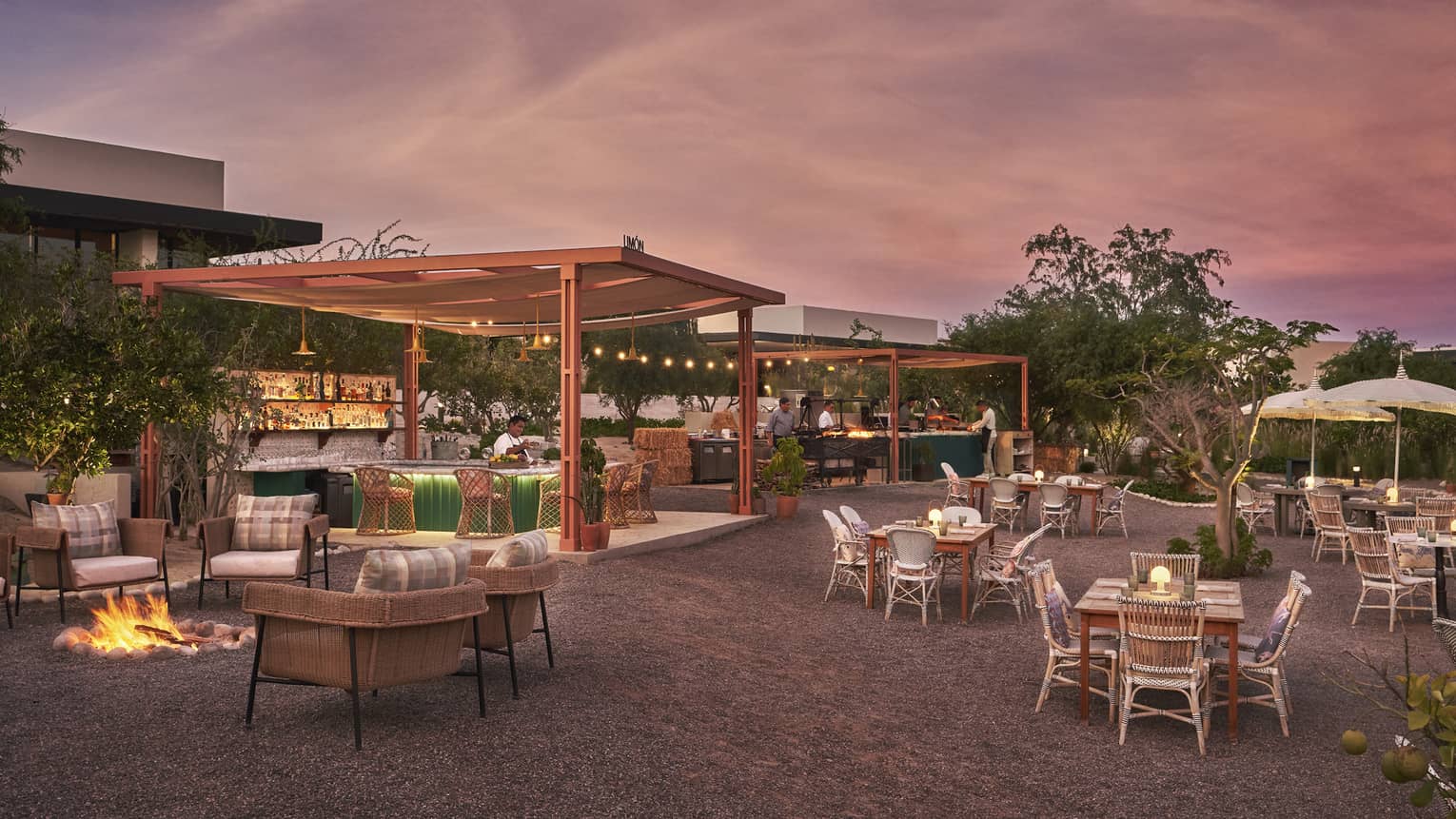 An outdoor eating area with a pink and blue sky above.