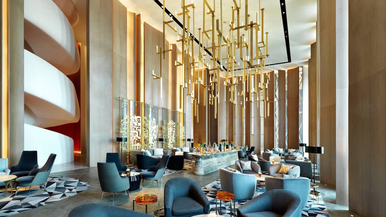 Modern dining chairs, tables in lounge with soaring ceilings, gold sculptures hanging from ceiling, wall