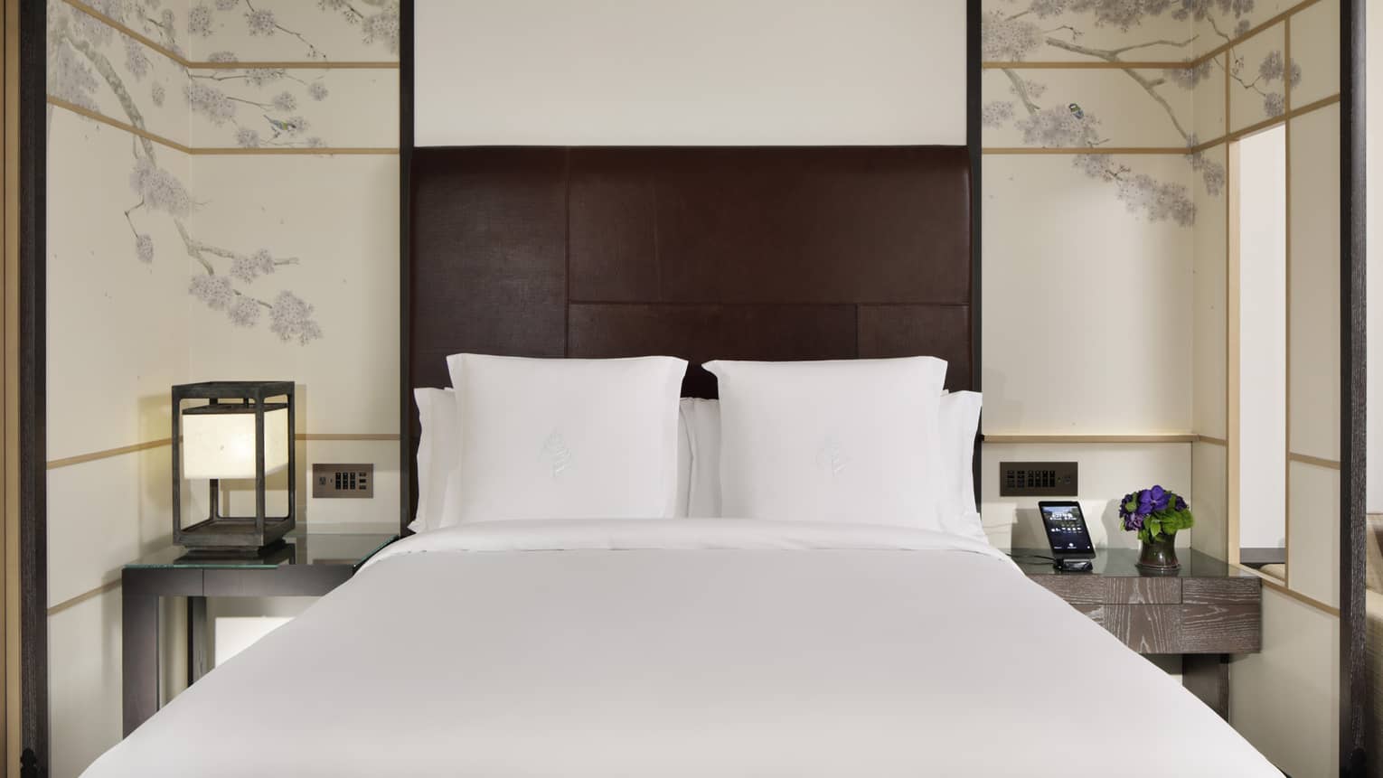 Hotel guest room with a king bed and Japanese-inspired wallpaper