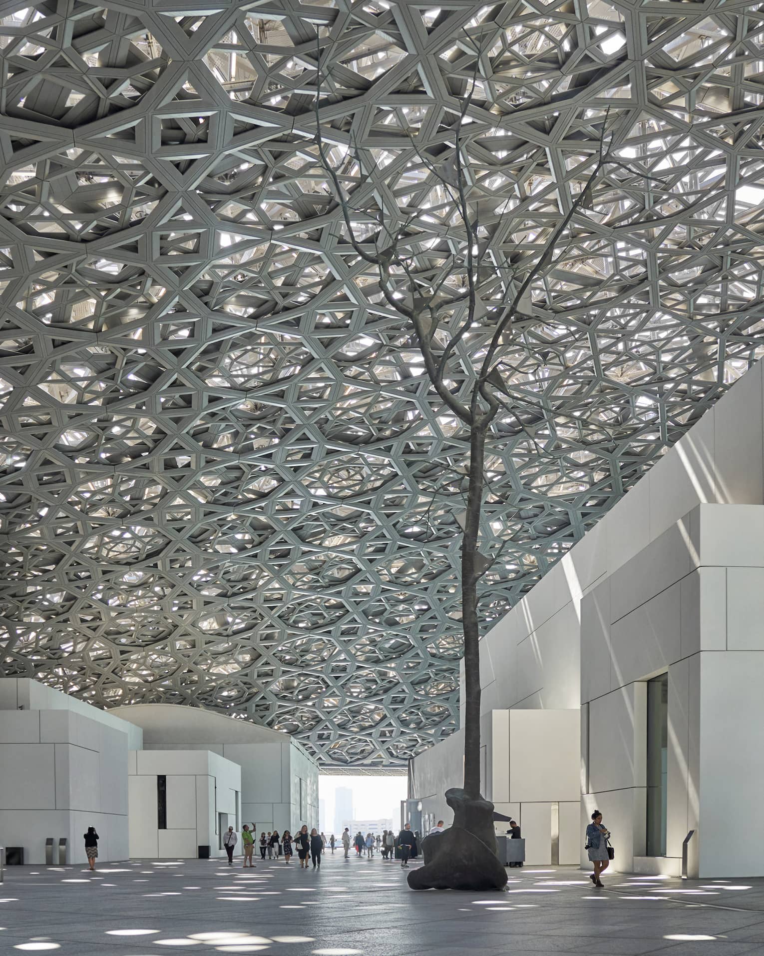 A large sculpture inside of a white stone building.