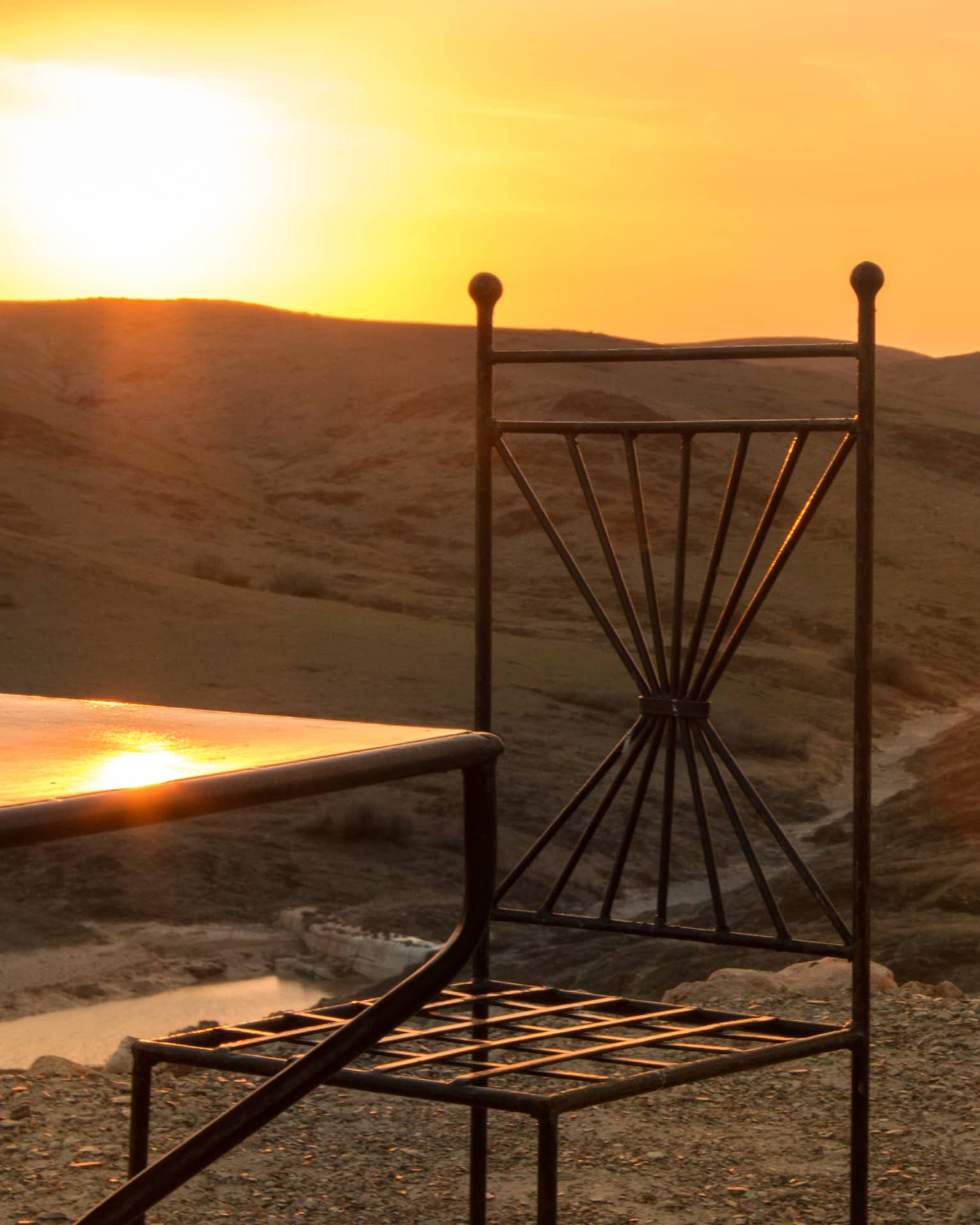 Corner of table, chair in desert at sunset