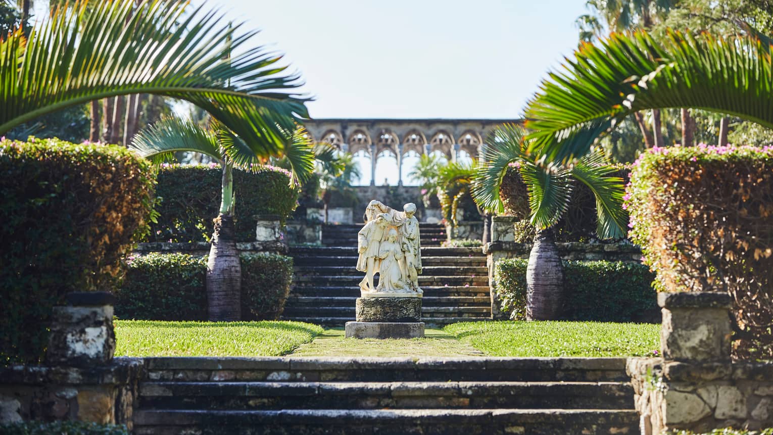 Marble statue in sunny, tropical gardens 