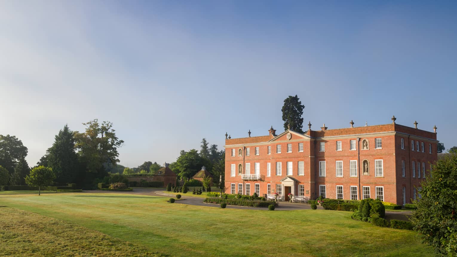 Four Seasons Hotel Hampshire red brick building exterior in rolling green countryside