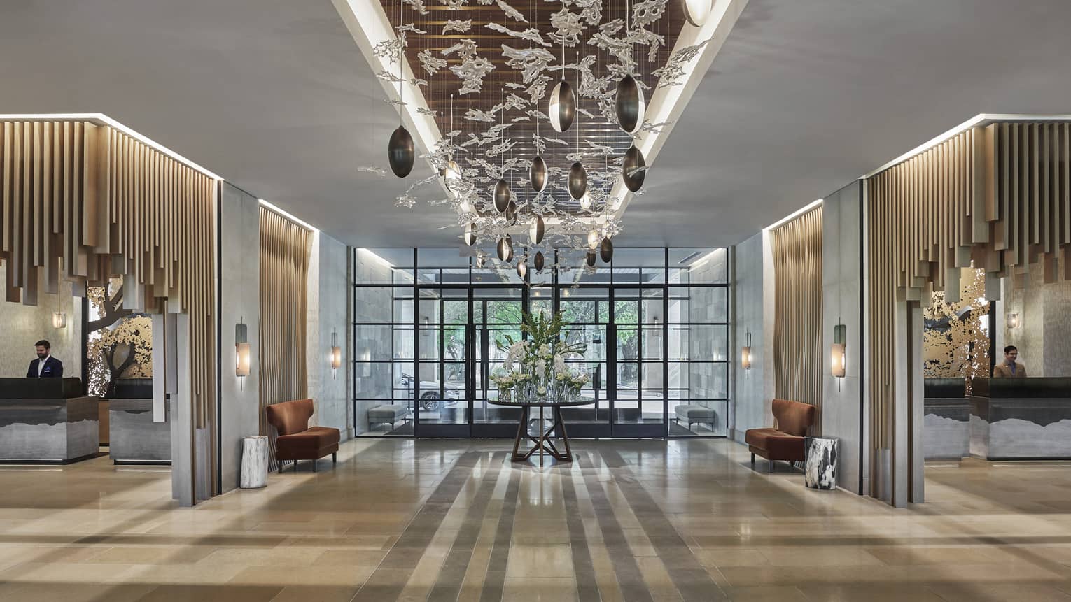 Delicate glass and rounded lights adorn the ceiling of a well-lit lobby