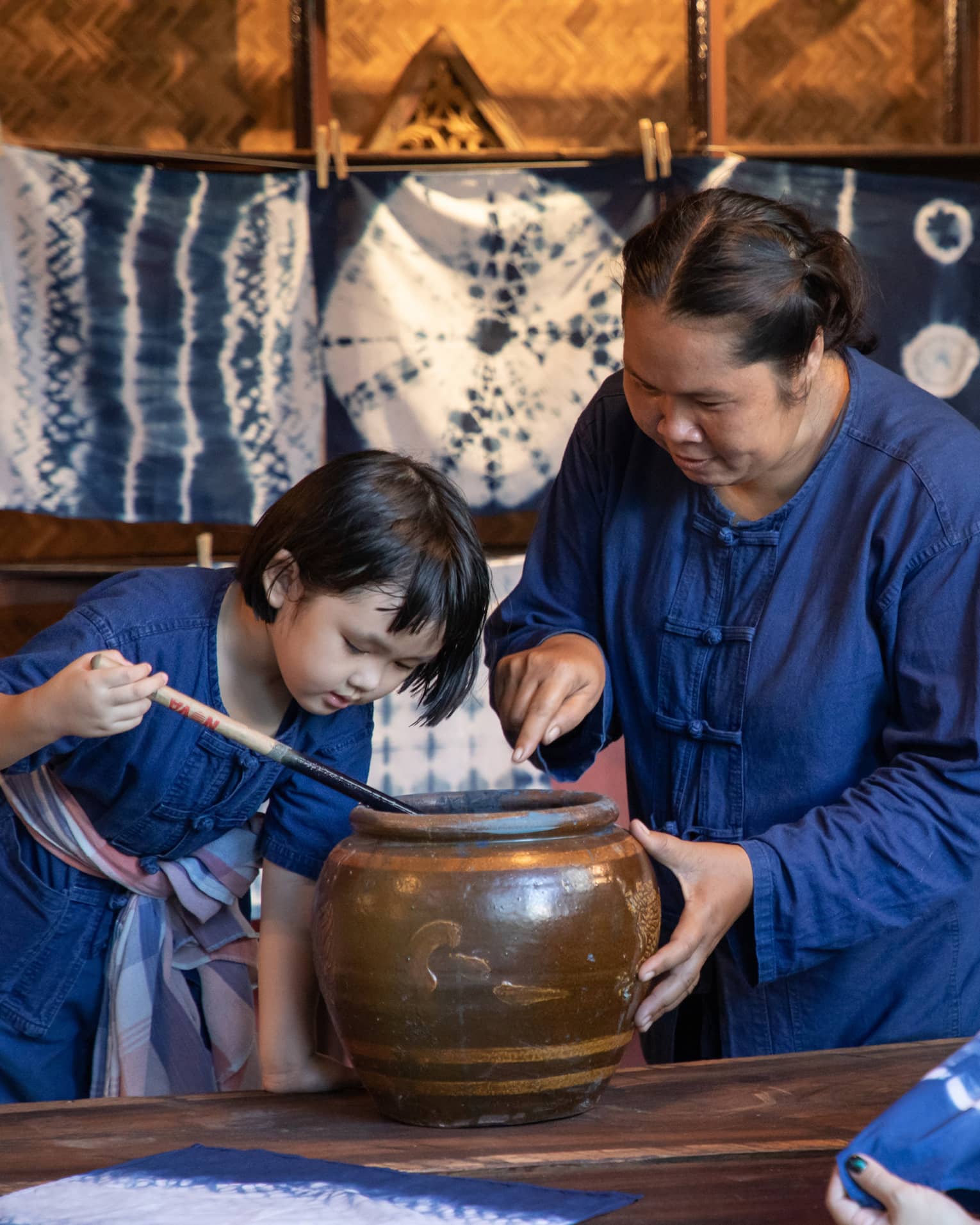 Instructor teaches child traditional tie dye techniques