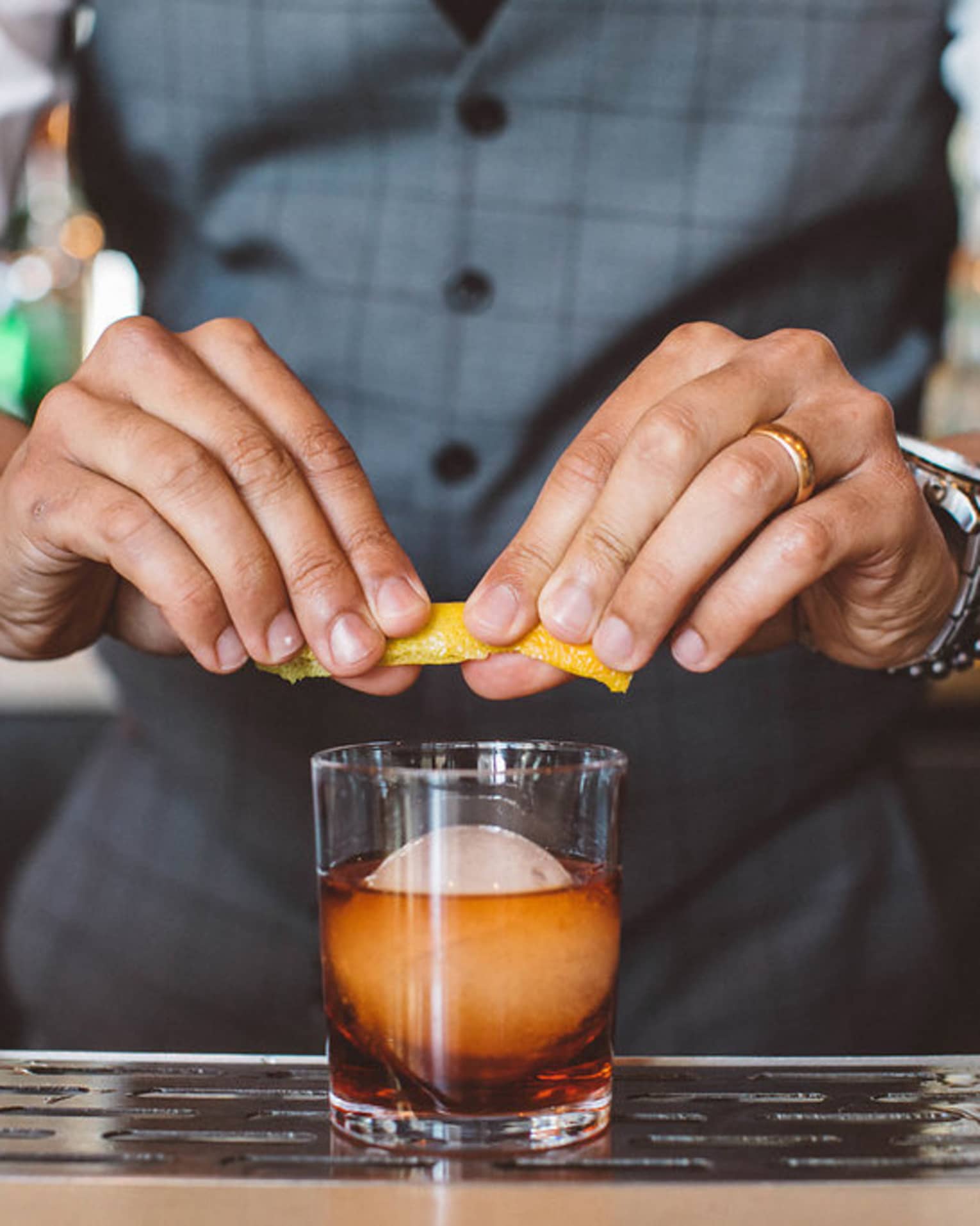 A bartender garnishing a cocktail.