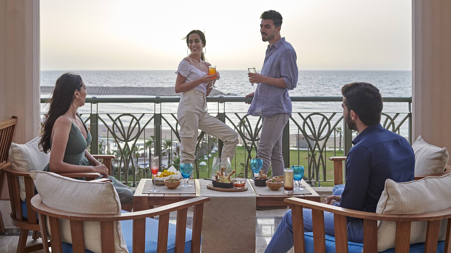 Two couples lounge on a terrace overlooking the ocean at four seasons alexandria