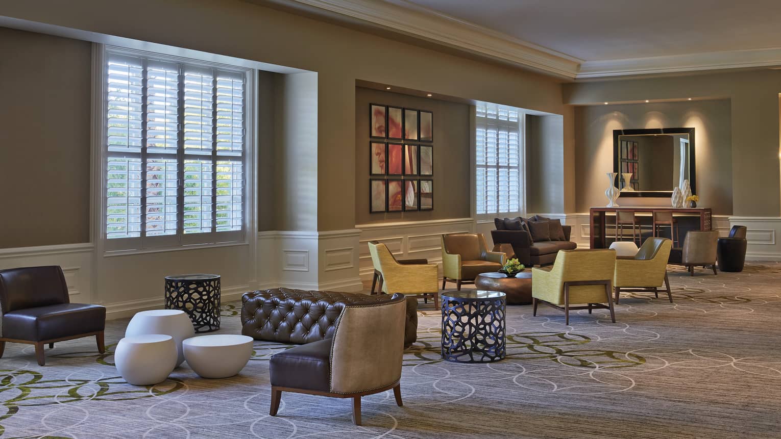 Modern armchairs, ottomans by windows in carpeted Four Seasons Ballroom Foyer
