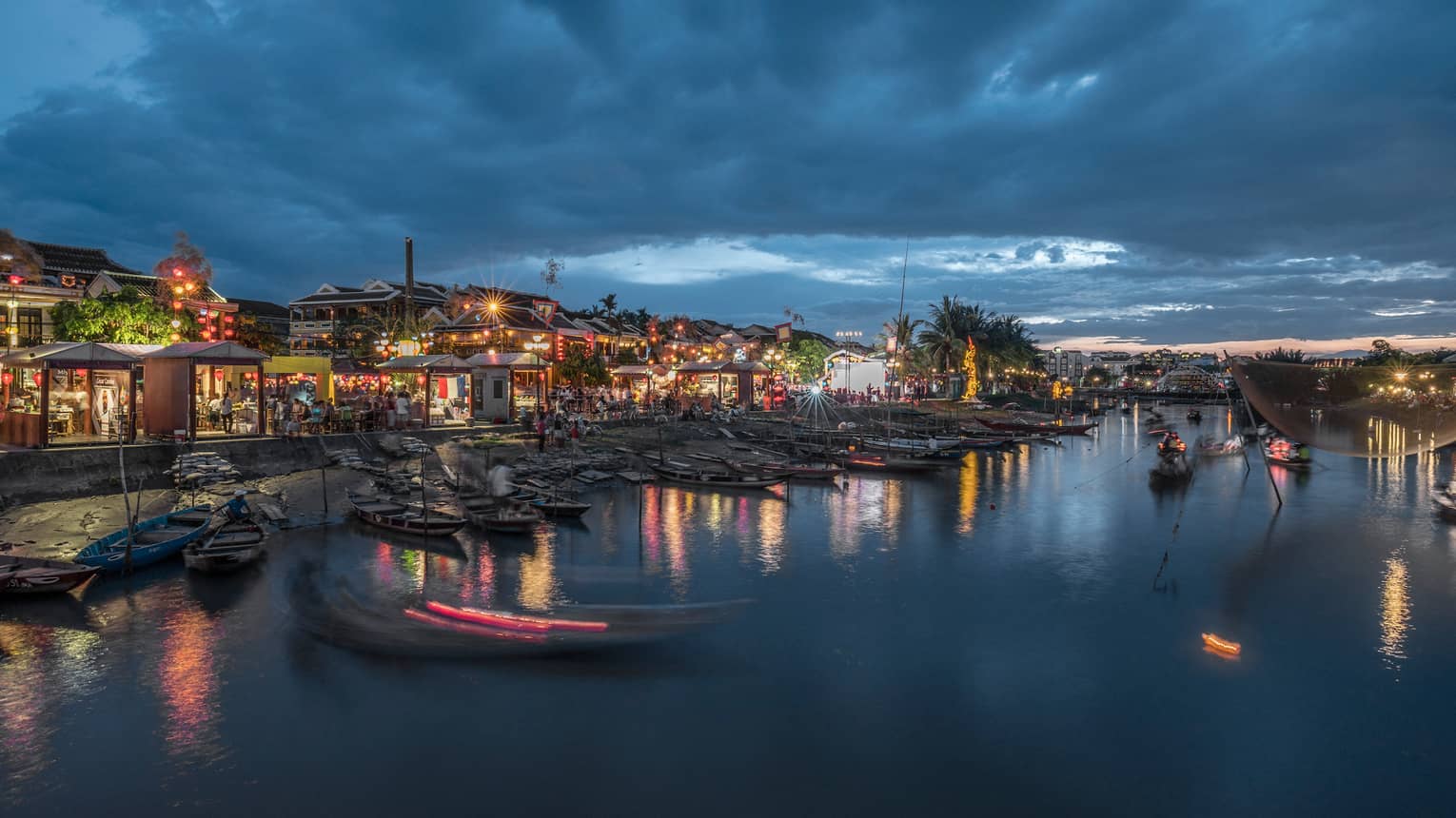 Colourful lights around buildings, markets on Hoi An waterfront at night 