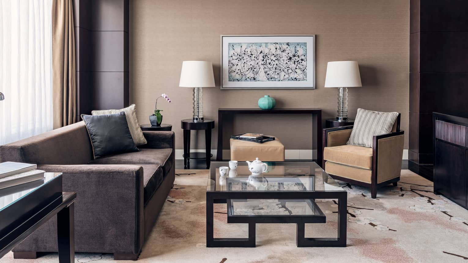 Brown coach, tan accent chair, glass nesting coffee table, brown and tan decor, floor-to-ceiling windows