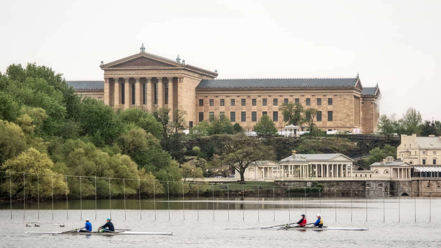 Kayakers row down river past historic buildings in Philadelphia