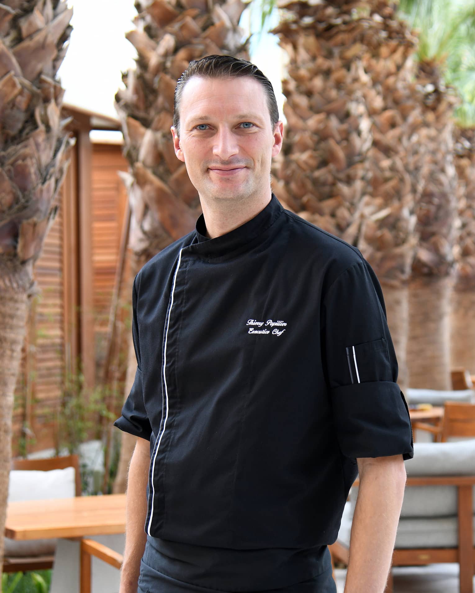 Chef Thierry Pillier stands looking at the camera wearing a black chef's jacket