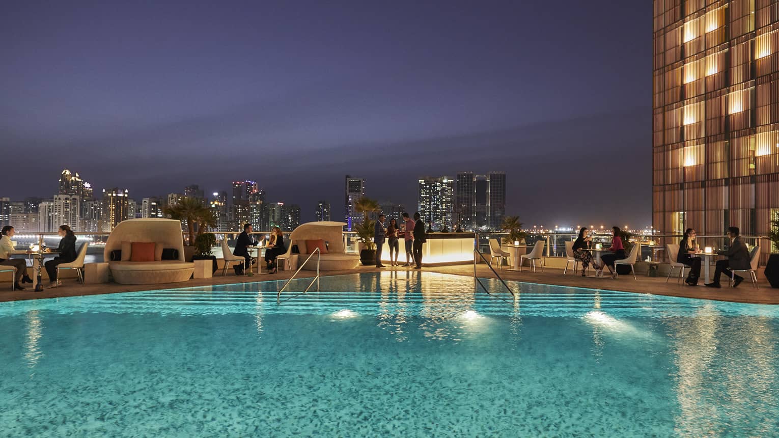 People gather around Eclipse pool at night 