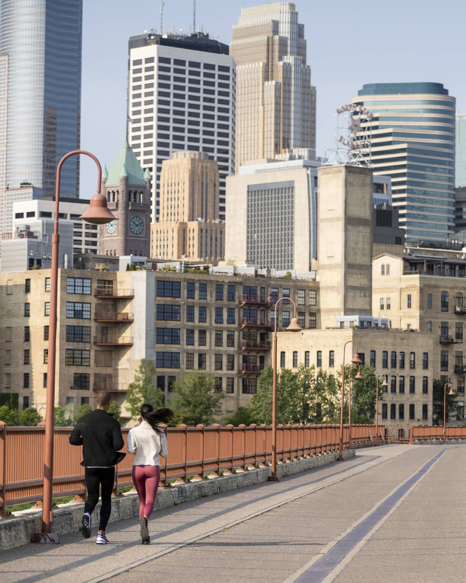 Minnesota city view from bridge, where two people run