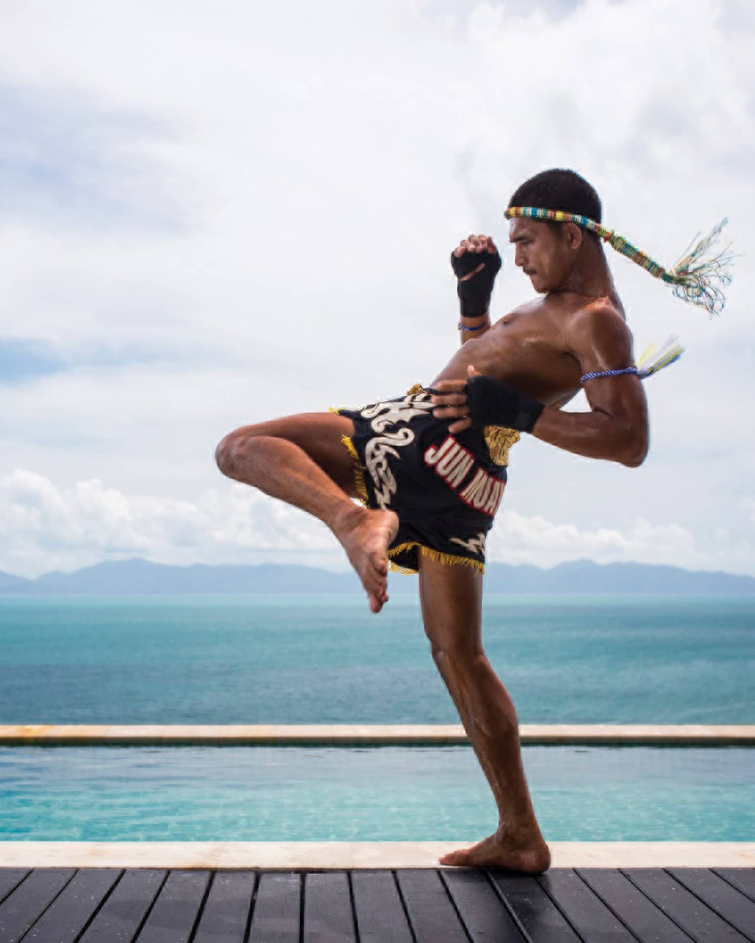 A guest practicing Muay Thai kickboxing by the ocean