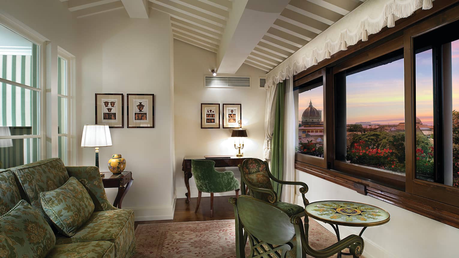 Duomo View Executive Suite green sofas, chairs and table by large picture window overlooking Florence, sunset