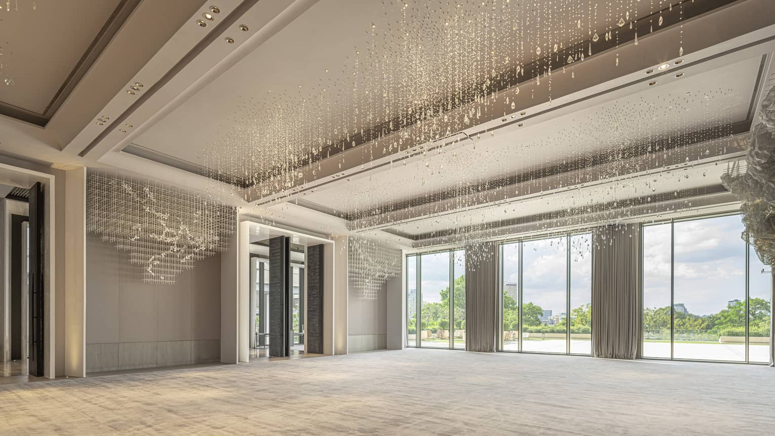 Grand Ballroom with cream-coloured carpeting and drapes, floor-to-ceiling windows and hanging crystal beads 